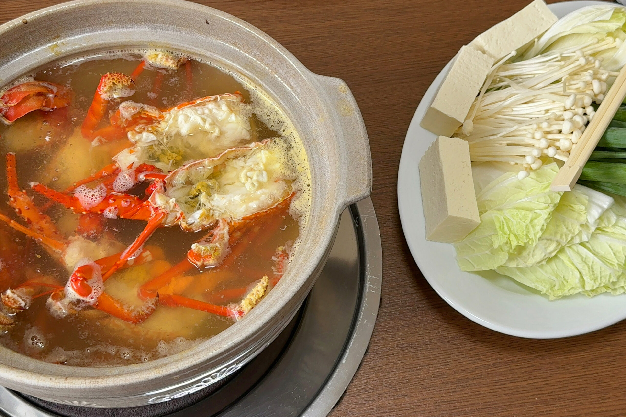 伊勢海老の旨みが溶け込んだ鍋に野菜と豆腐を入れた様子